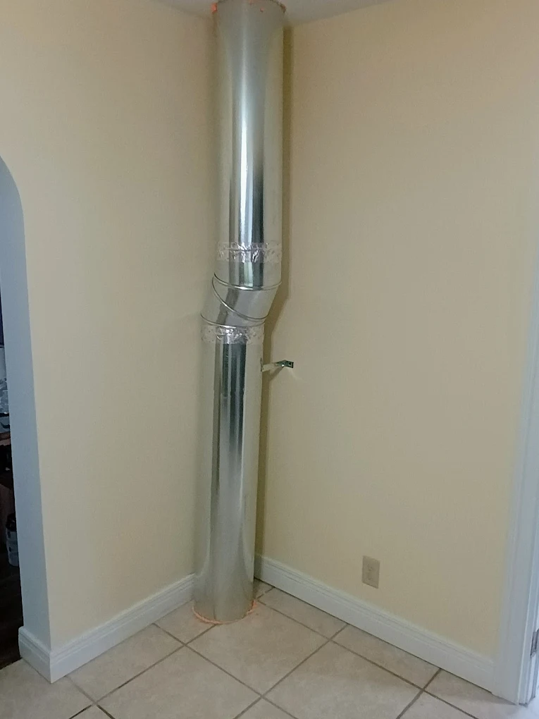 Exposed metal ductwork running up a corner wall