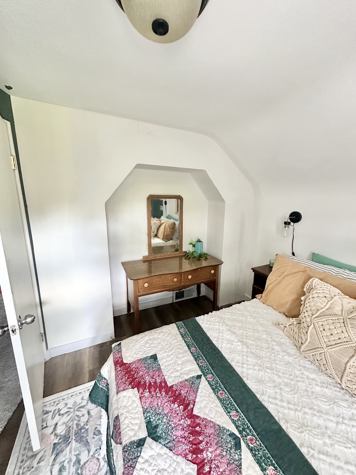 Finished, painted bedroom with a vanity tucked into the arched alcove